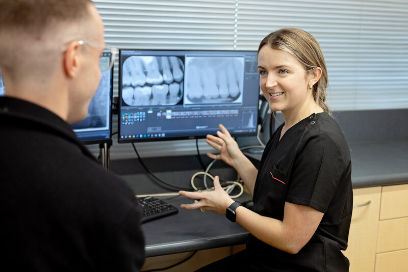 patient sitting down with dentist and talking through upcoming procedure