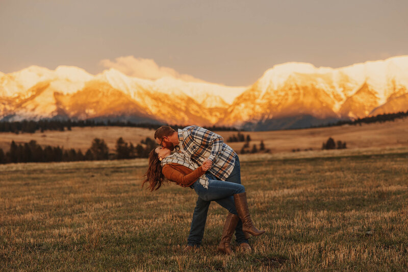 couple kissing in front of mountain range