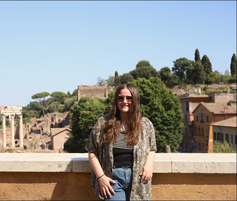 Woman wearing sunglasses posing in front of roman forum