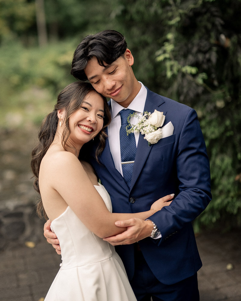 Bride and groom sit on a green couch for a portrait at their Elkins Estate Wedding.