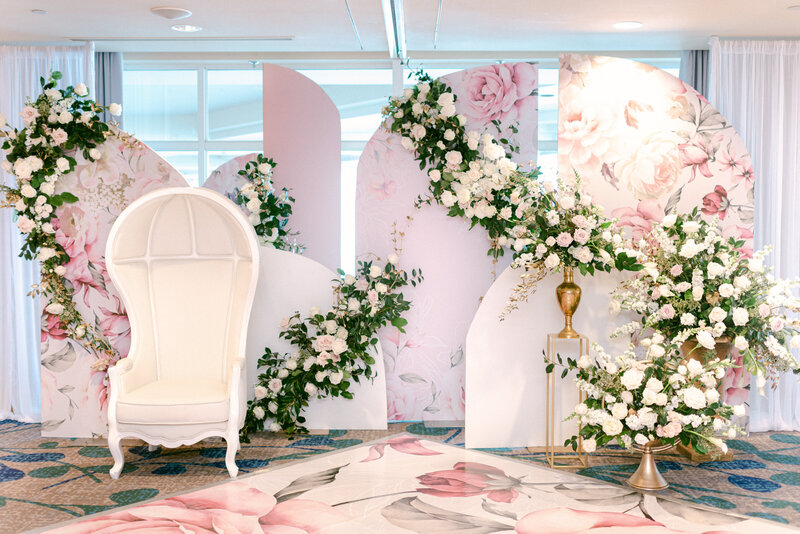 event room filled with pink arches and white roses for a sikh bridal shower