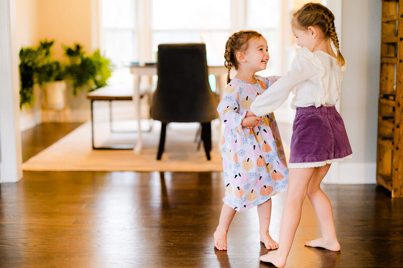 Two sisters dancing at an in home family photo session near Chicago.