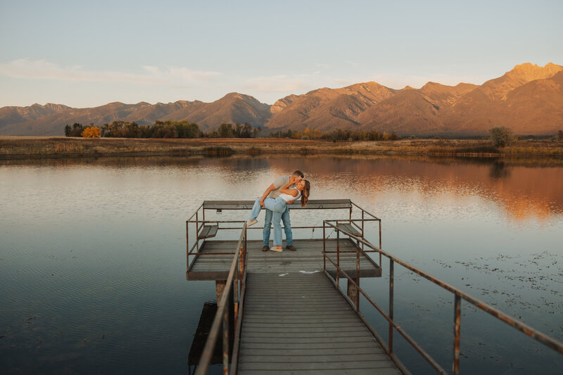 Couple kissing at the end of a wooden dock on a Montana lake during their romantic elopement.
