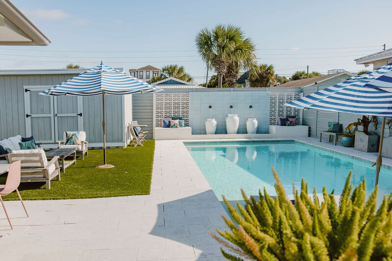 pool with striped umbrellas and sitting area