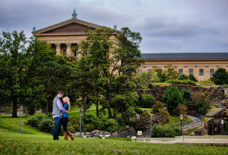Engaged couple standing together with the iconic Philadelphia Museum of Art in the background during their engagement session.