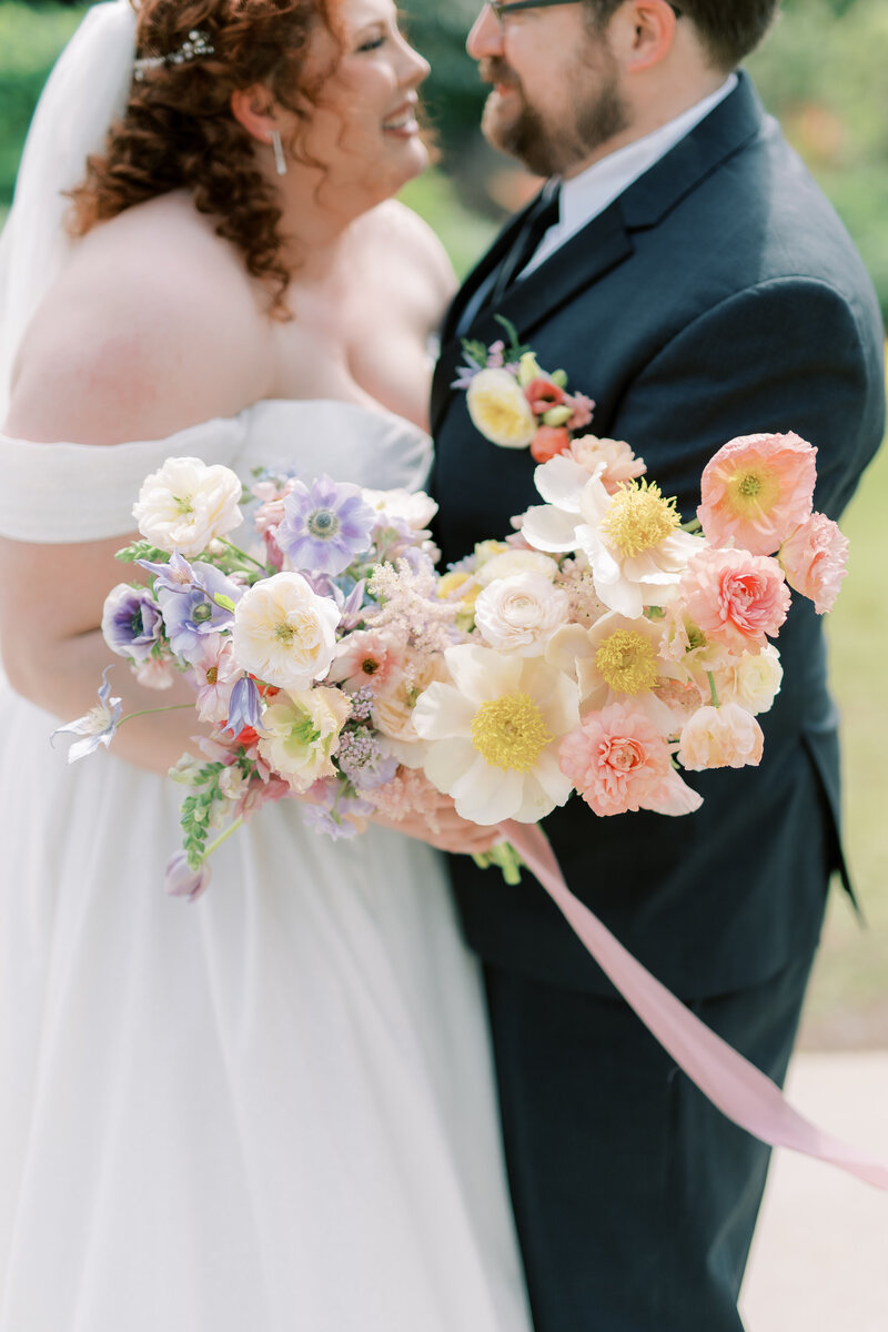 Outdoor table setting with colorful flowers, gold cutlery.