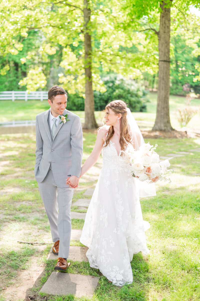 A close up shot of a bride and groom, kissing on their wedding day with a blurred green field behind them.