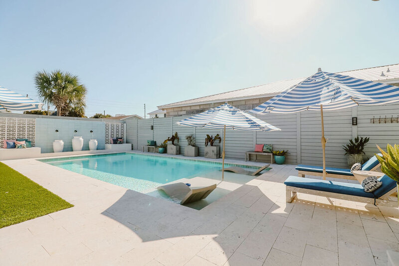 pool with in water loungers striped umbrellas