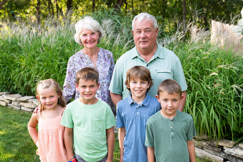 Grandparents stand with their four grandchildren during their extended family photo shoot.