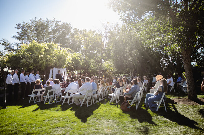 Guests are seated in front of a gazebo watching a wedding ceremony