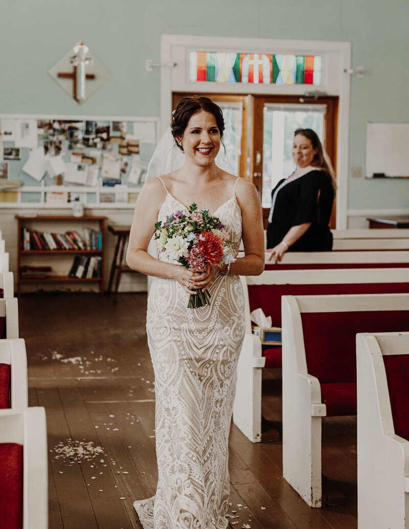 bride walking down isle with bouquet of flowers