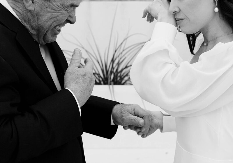 close shot of bride and groom holding hands and crying on their wedding day by wedding photographer minnesota tom thornton photography