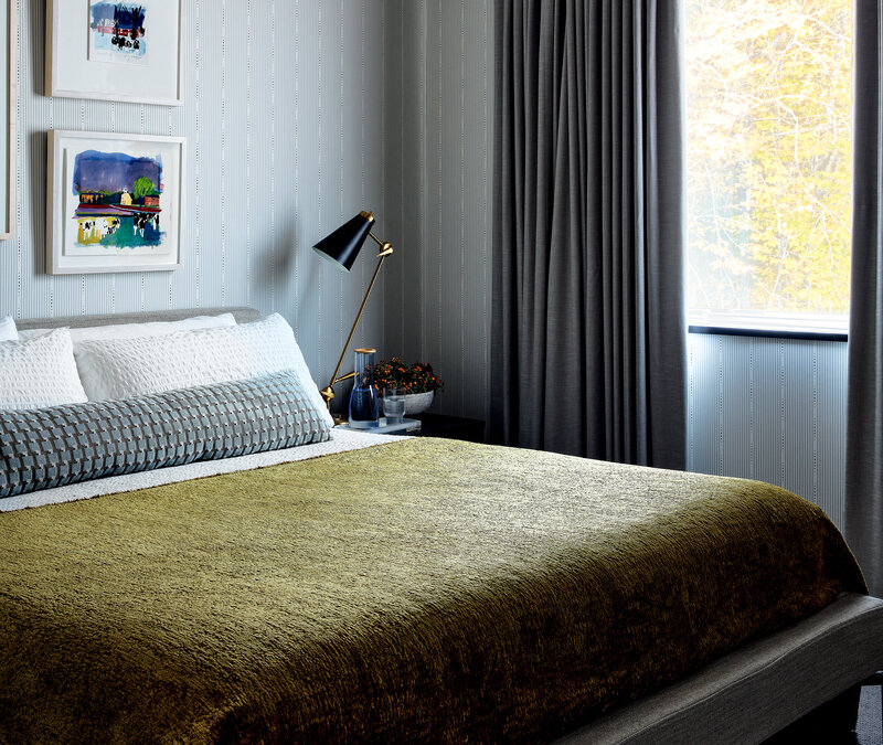 Interior decorators in Boston created a modern bedroom in a new Vermont home with Schumacher wallpaper, custom drapery, and unique bedding for a fresh, tailored look.