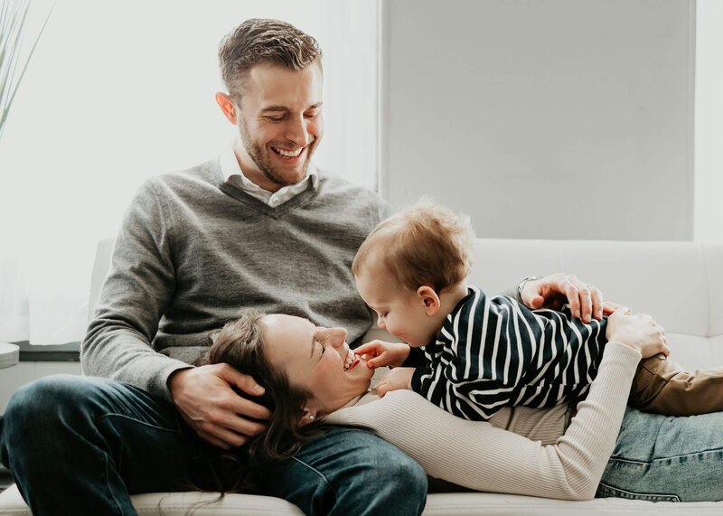 Capture a Pittsburgh family photographer as they sit on a couch with their baby on their lap.