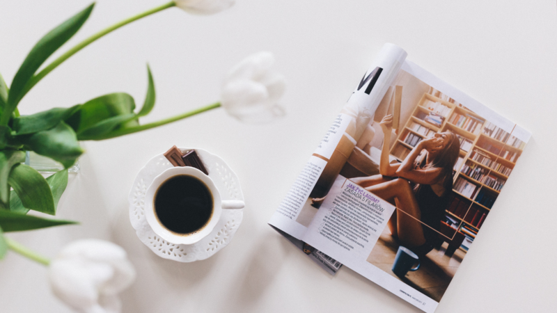 Black coffee, white tulips, and an open magazine
