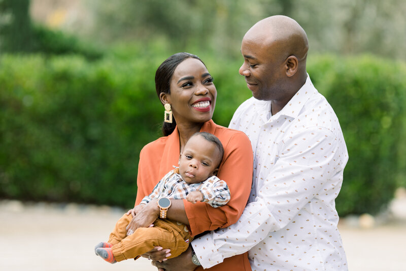 Family Photography - Family of four standing together parents holding the two young children