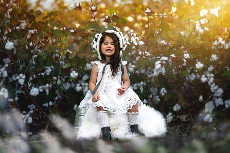 Beautiful girl dressed in white posing on a cotton field near Houston, TX.