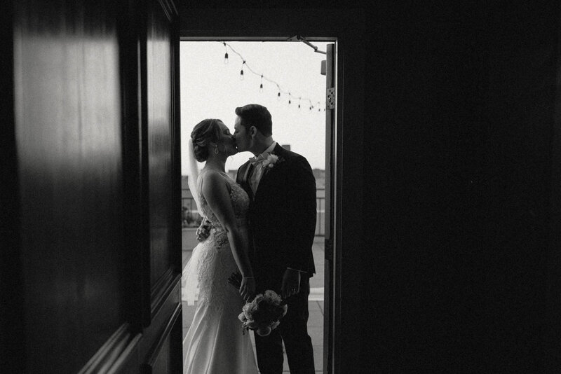 Newlywed couple kiss in doorway