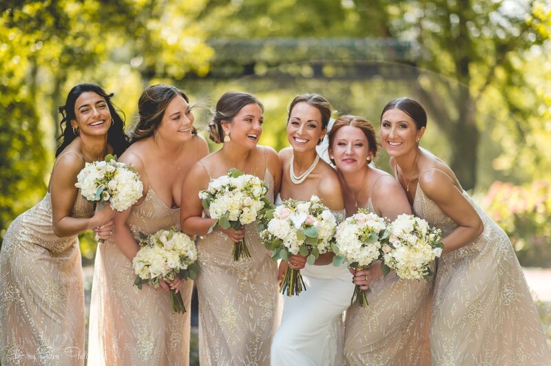bride and bridesmaids smiling and holding bouquets