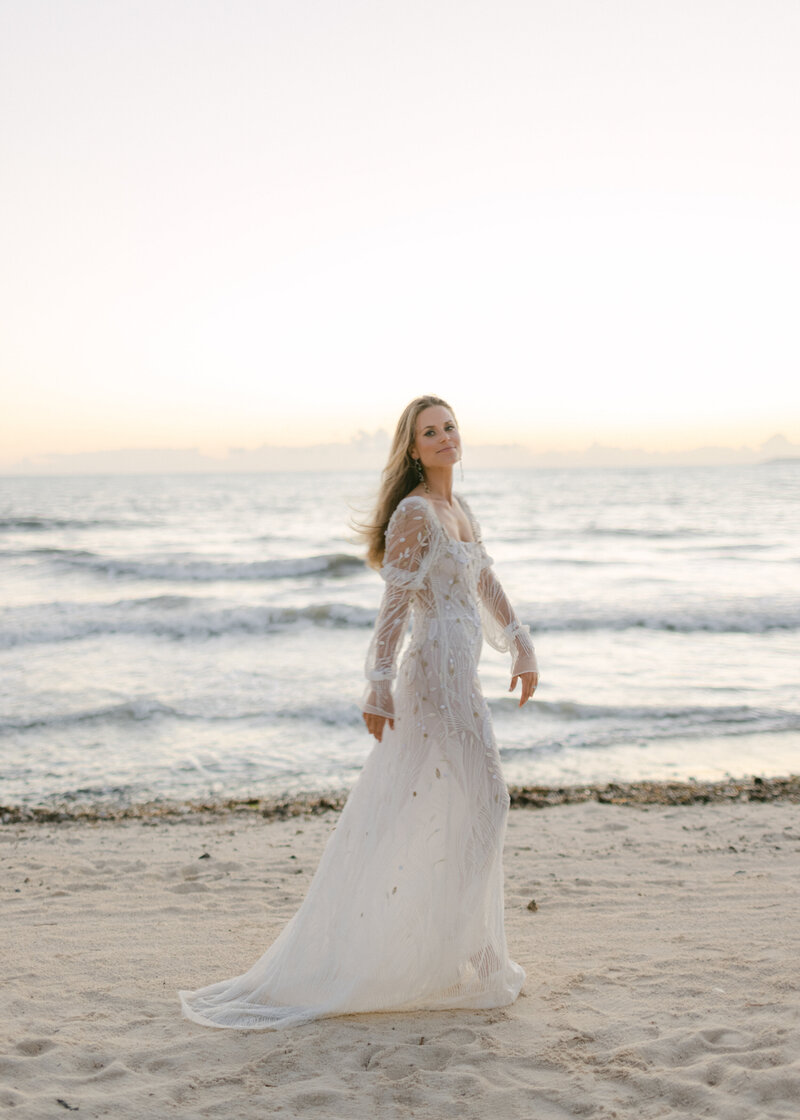 Bride walks along waters edge