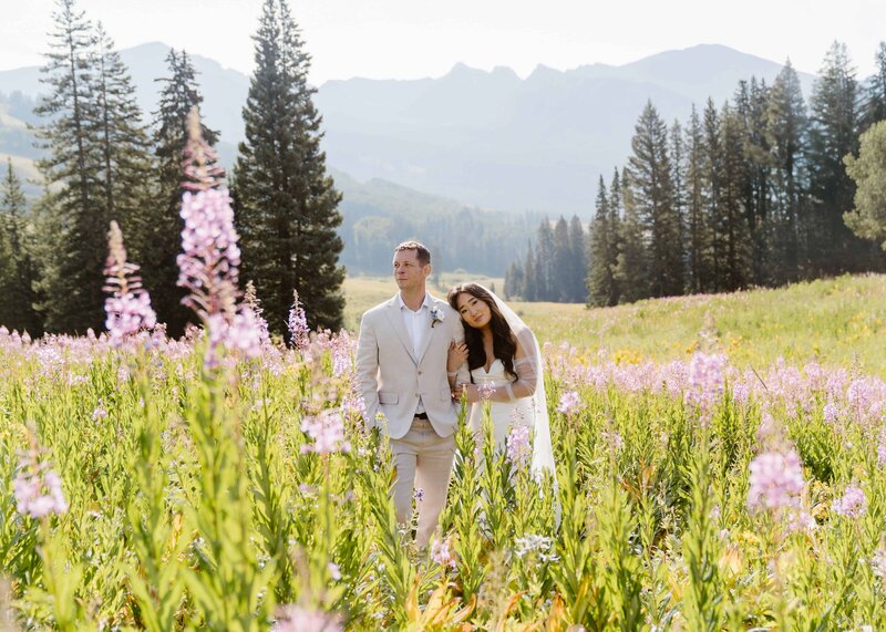 couple snuggles up together in a field of wildflowers during their elopement with Crested Butte, Colorado elopement photographer and videographer Alpine Vows