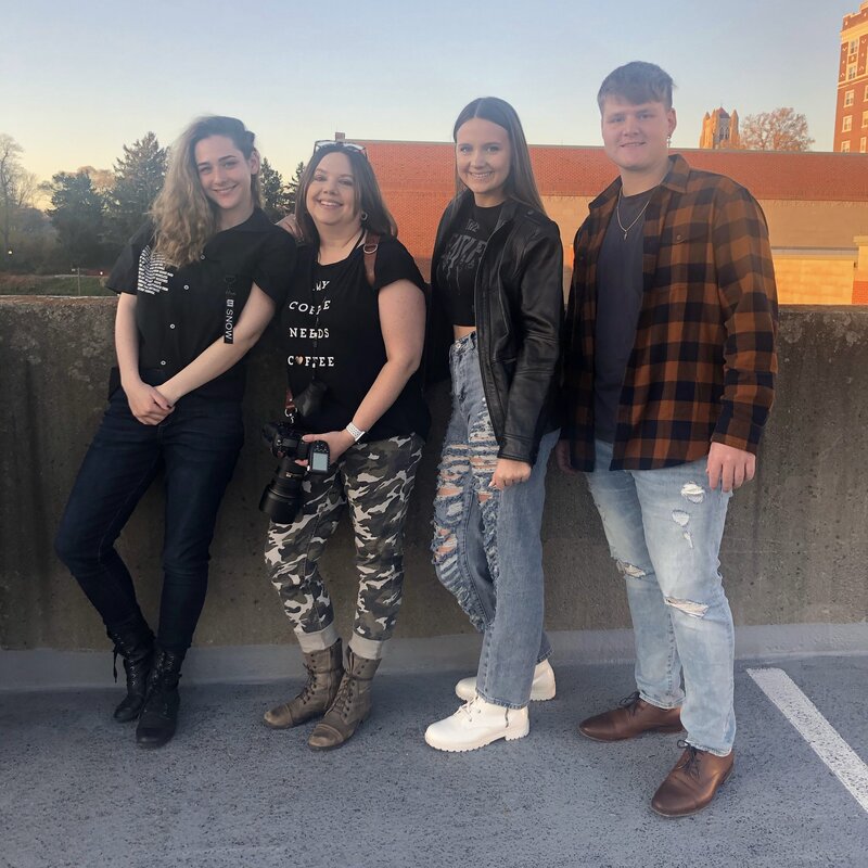 Photo of photographer with group of seniors on roof of parking garage at sunset