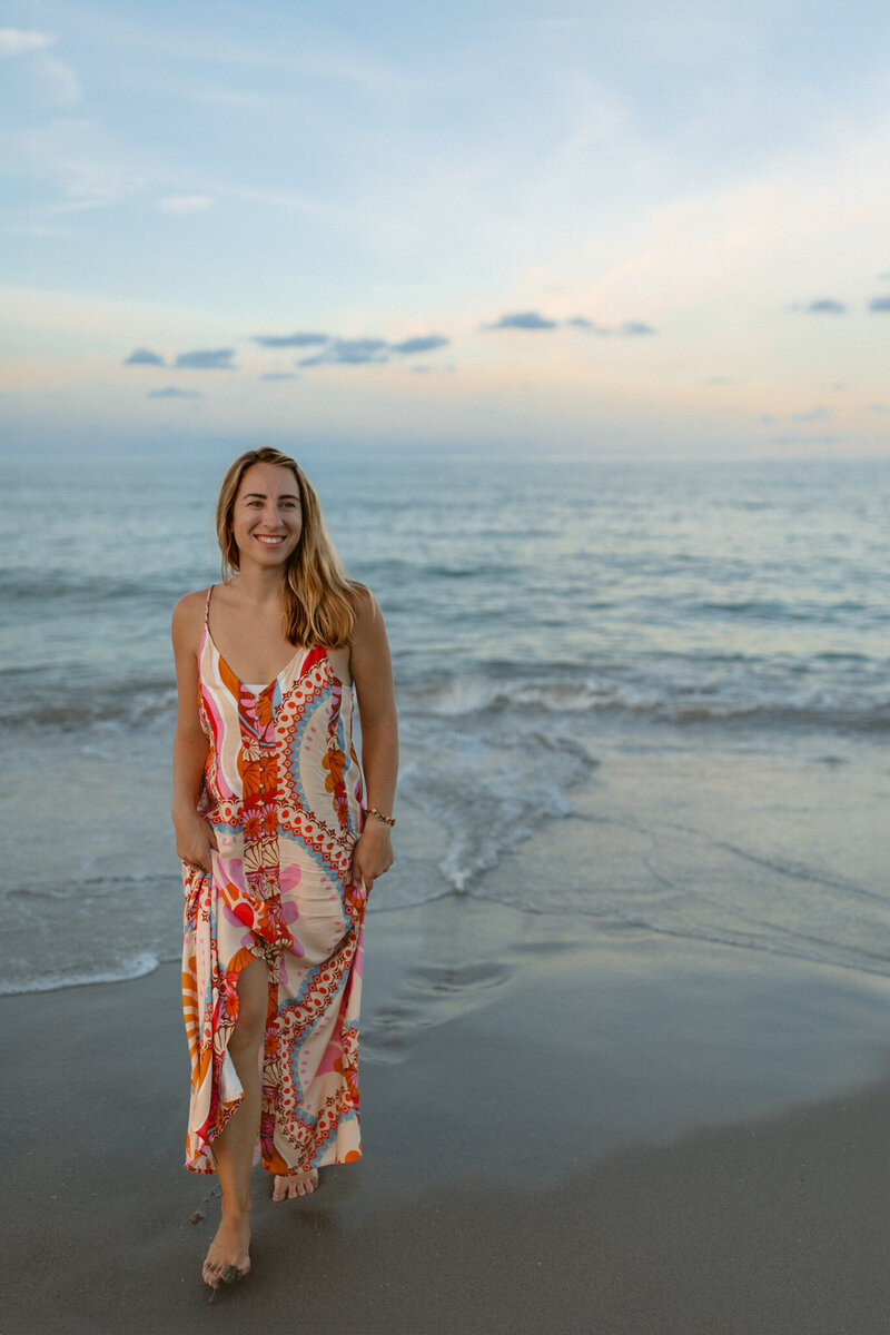 woman walking on the beach in a bright colored beachy dress
