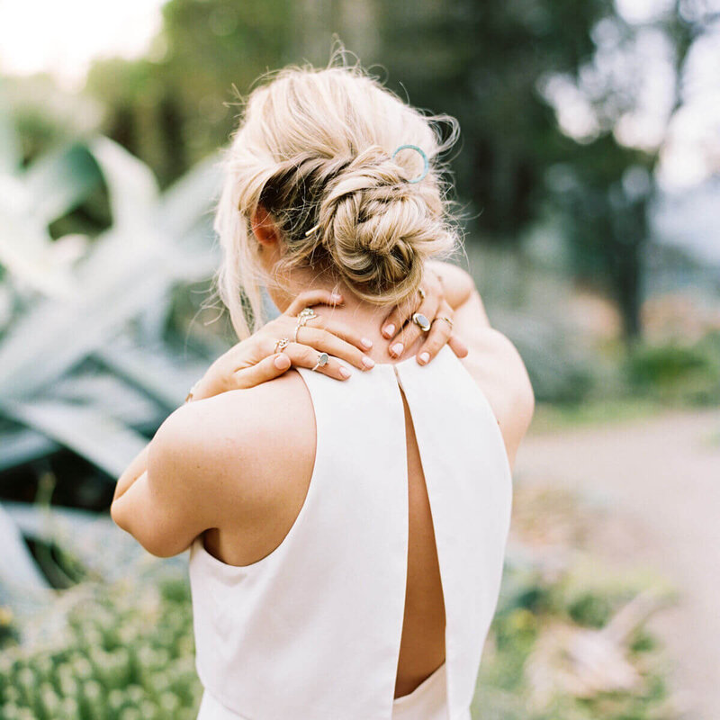 blonde woman hands behind neck thinking