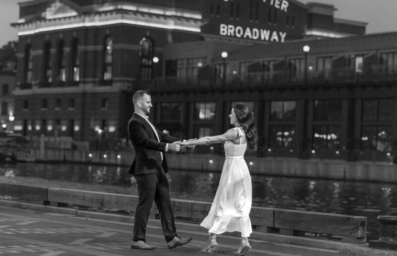beautiful engaged couple dancing on boardwalk pier at fells point in baltimore maryland photo by sabrina leigh