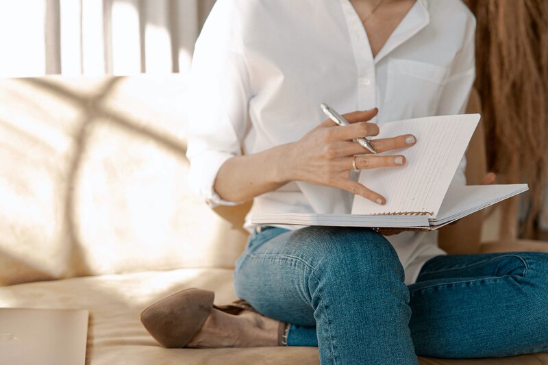 Woman sitting on a couch with a journal
