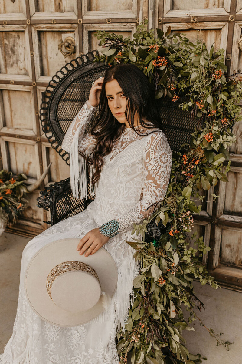 bride sitting in a chair covered in flowers
