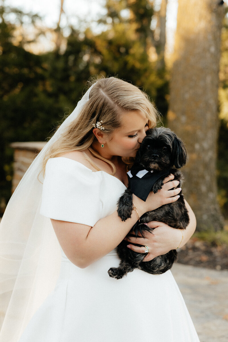 A bride kissing her dog.