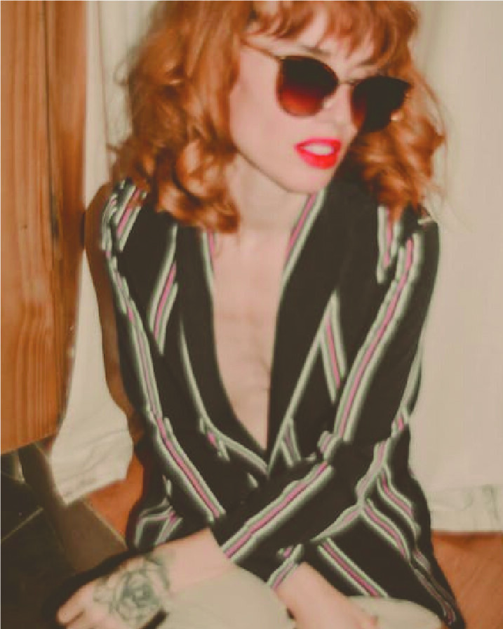 polaroid filter photo of a red haired woman in sunglasses with a striped blazer fashion magazine style