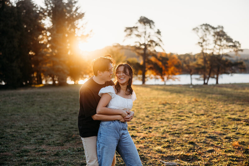 Engaged couple embrace and laugh during their engagement photo shoot in Yarralumla ACT. Photo by Acacia & Grace Photography, a wedding, elopement and engagement photographer based in Canberra.