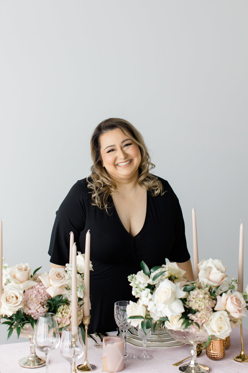 Jessie Khaira, luxury sikh wedding planner smiling at her desk looking at her laptop