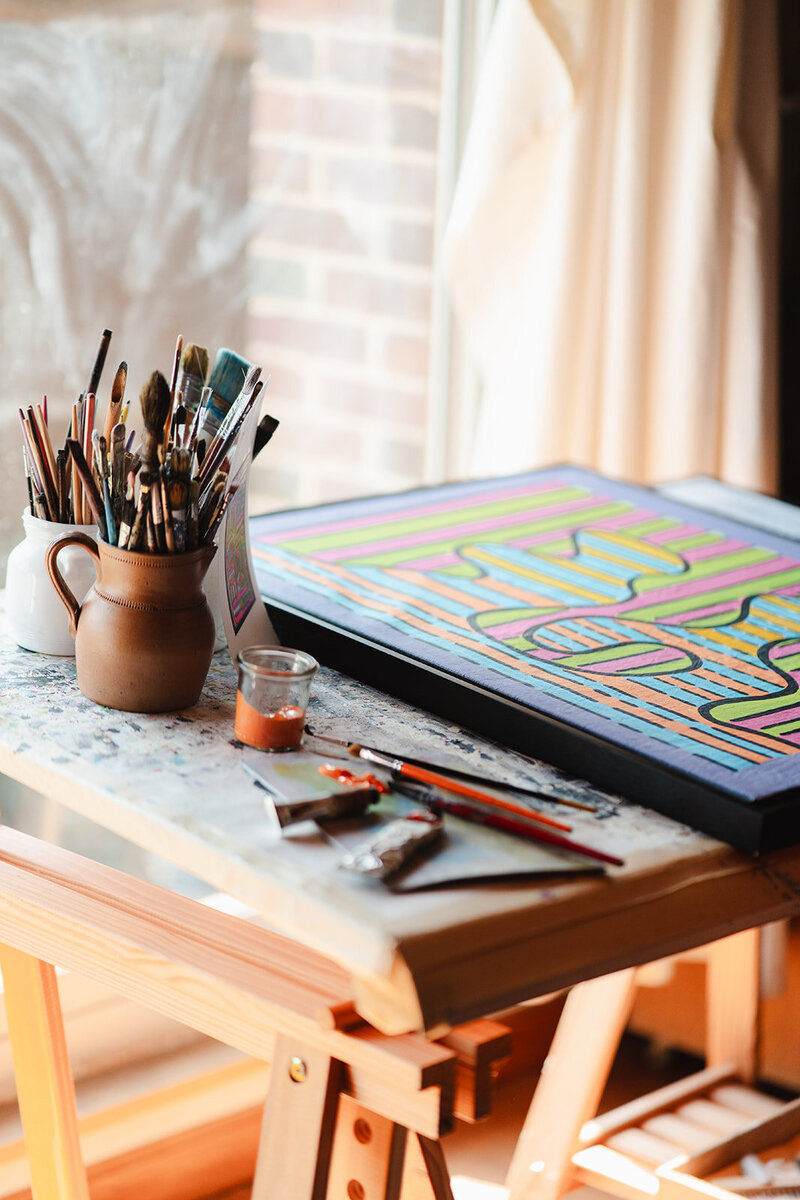 table sur laquelle créait paul teneze avec un tableau et pinceau