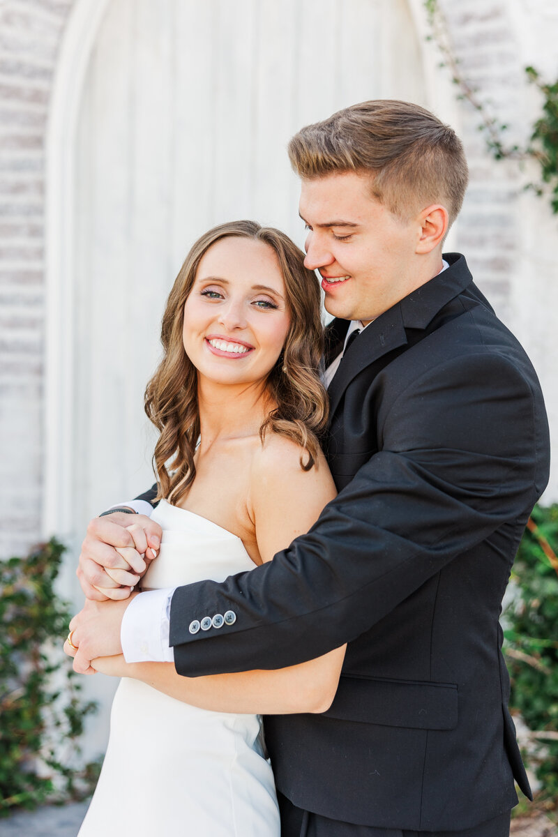 a bride and groom hugging on their wedding day