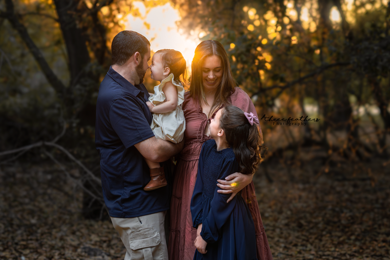 photo of a family of 4 during a woodsy, sunset family photo session