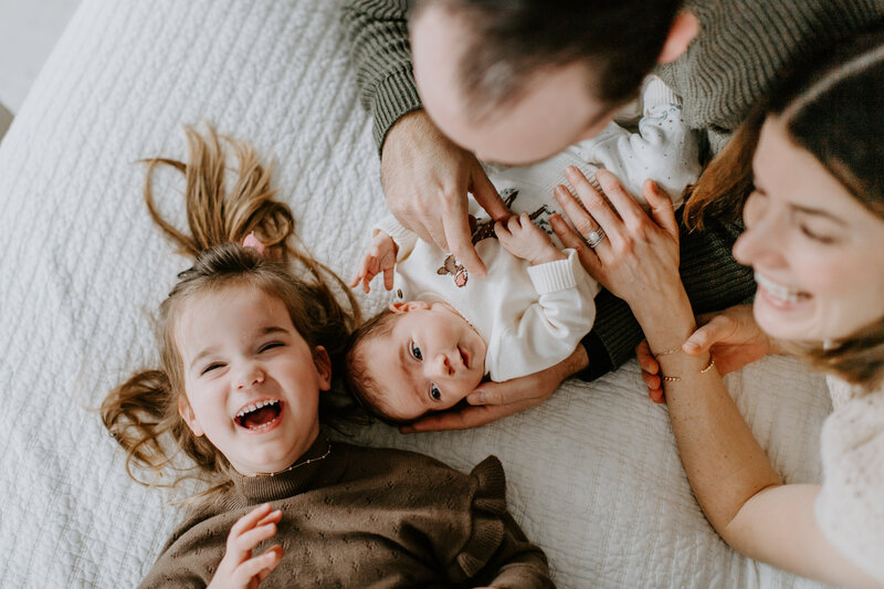 Newborn Photographer, mother holding newborn with toddler leaning against her