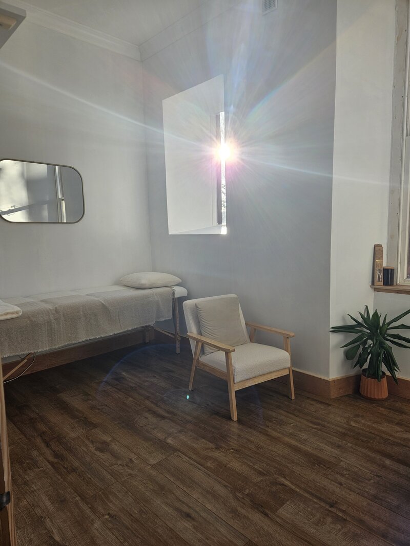 1:1 room within The Wellness Studio, with treatment bed and comfy chairs.