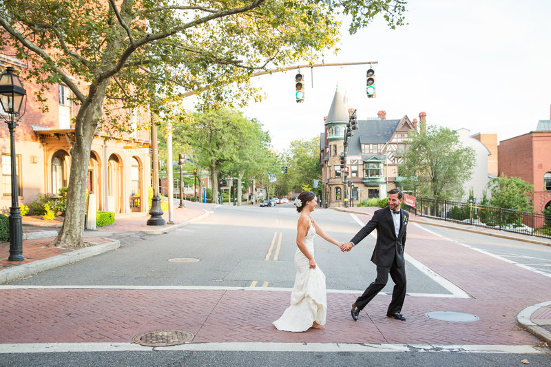 Bride and Groom walk across the streets in Providence at Golden Hour