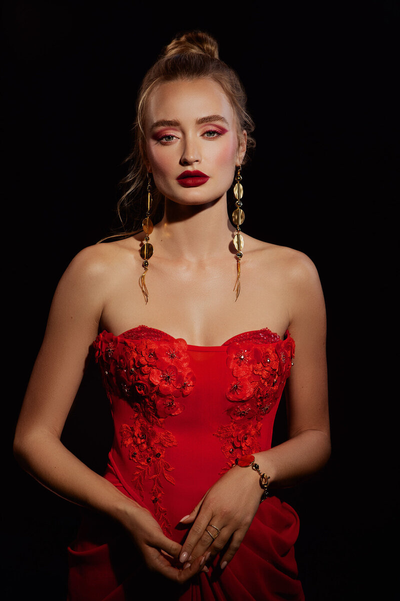 Elegant portrait of Zoey Kay in a strapless red dress with bold red lipstick, captured by Ylva Erevall.
