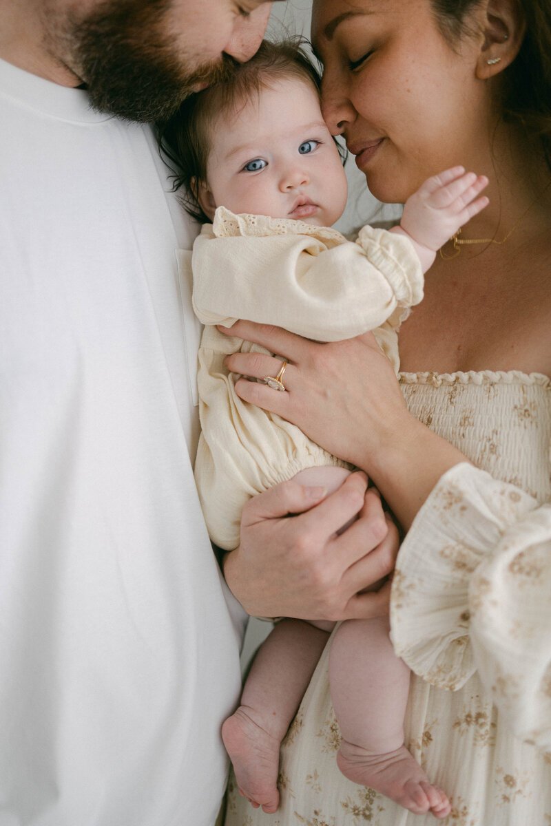 knoxville tennessee newborn photographer family snuggled up on the floor together holding each other with baby looking at camera