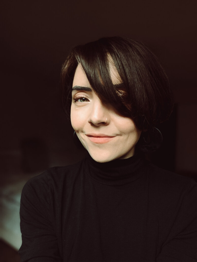 Selfie of a brown haired woman in turtleneck, smiling to the camera