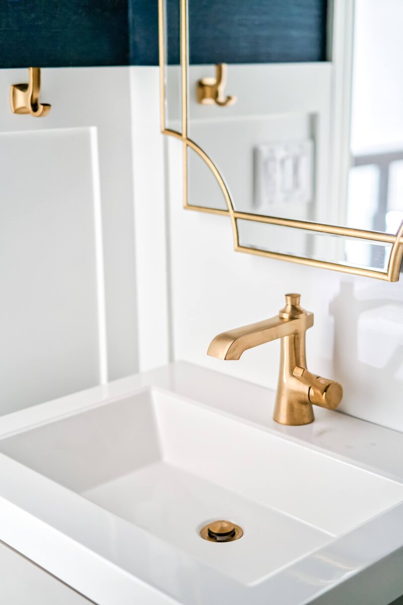 Gold faucet and mirror in bathroom at Modern Mission_Scarbro Design