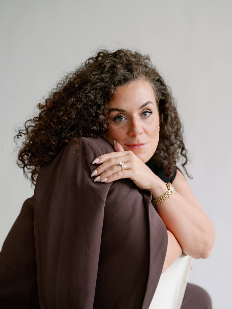 woman with curly hair smiling at at the camera