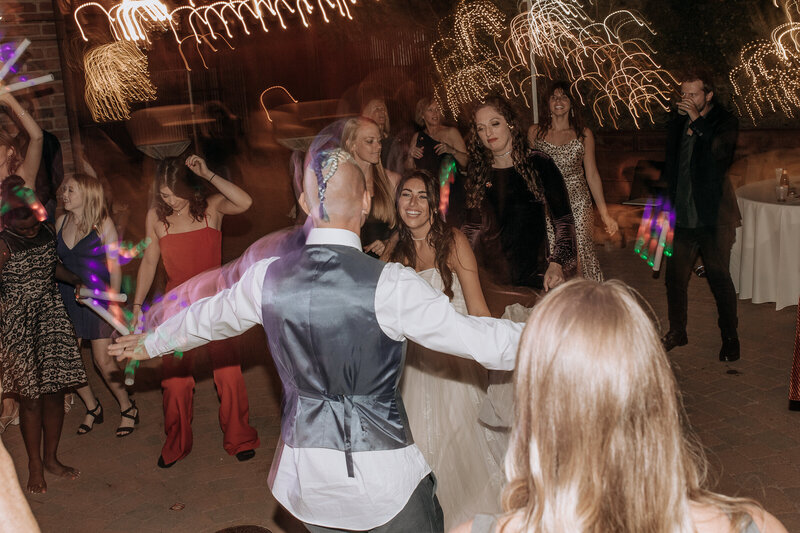 bride laughing at groom dancing at wedding reception in arizona