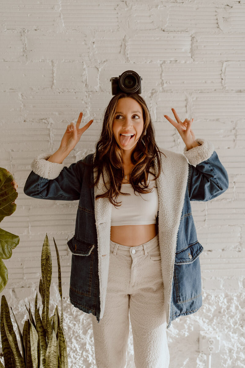 photographer posing with camera on her head