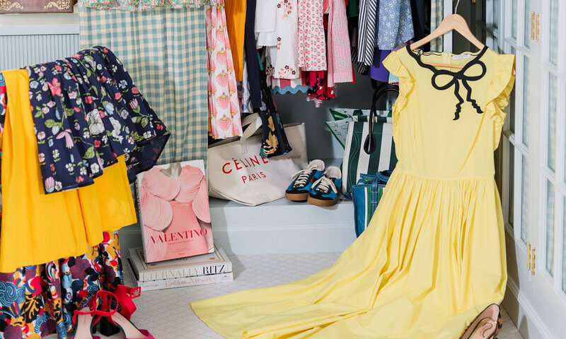 Colorful clothing folded and hanging on racks with books and shoes on the floor