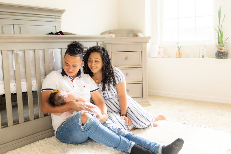 Parents smiling at newborn in Apopka home photo session